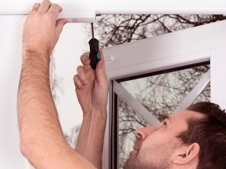 Un tecnico monta l'allarme per porte e finestre